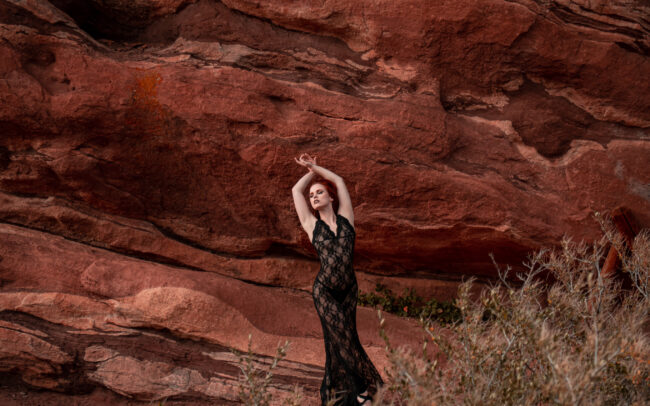 Krystal Kitten in a long black gown, in a red canyon